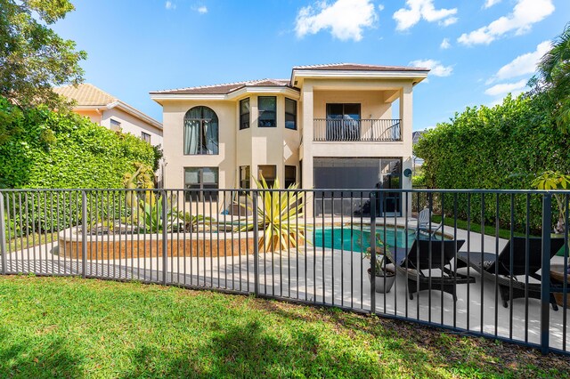 back of property featuring a fenced in pool, a patio area, a balcony, and stucco siding