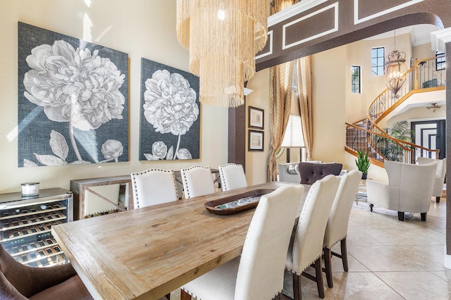 tiled dining space featuring a chandelier, arched walkways, stairs, and a towering ceiling