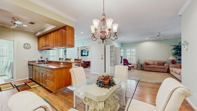 kitchen featuring open floor plan, ceiling fan with notable chandelier, dark countertops, and a sink