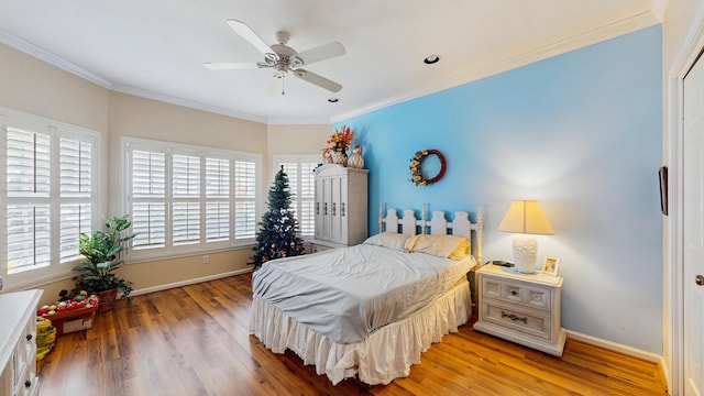 bedroom featuring multiple windows, wood finished floors, and baseboards