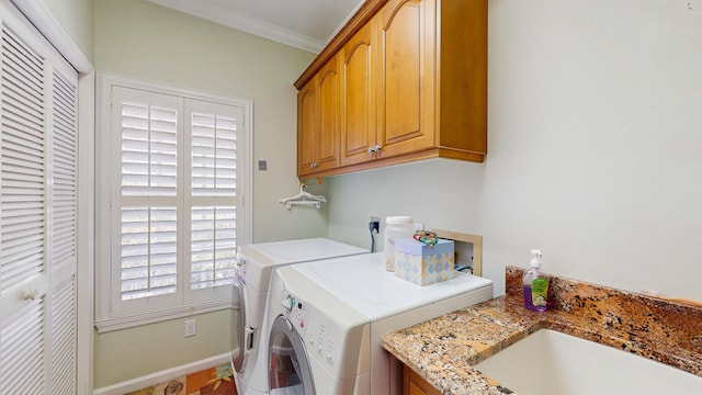 clothes washing area with crown molding, cabinet space, a sink, washer and dryer, and baseboards