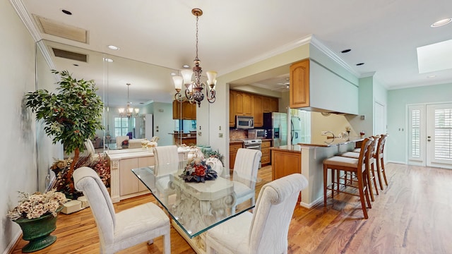 dining area featuring recessed lighting, light wood-style flooring, an inviting chandelier, ornamental molding, and baseboards