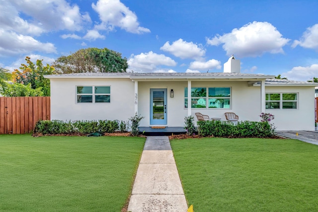 ranch-style house featuring a chimney, fence, a front lawn, and stucco siding