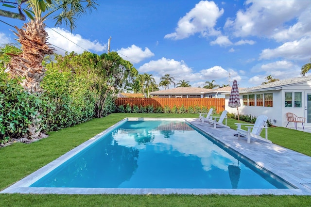 view of swimming pool featuring a patio, a lawn, and a fenced backyard