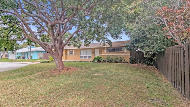 single story home with a front lawn, fence, and stucco siding