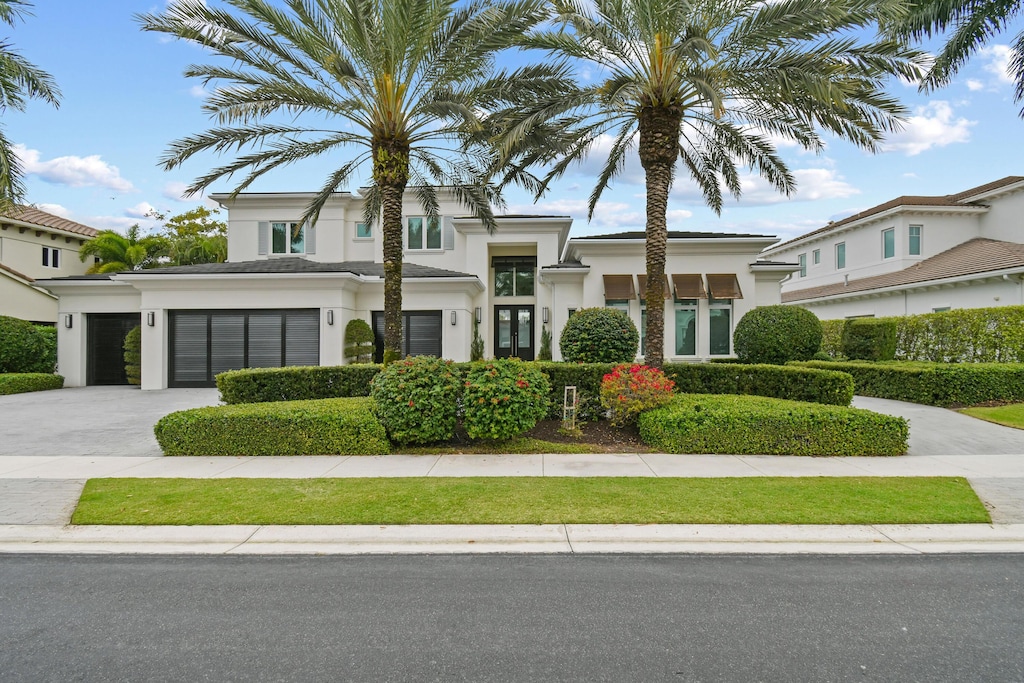 view of front facade with a garage, concrete driveway, and stucco siding