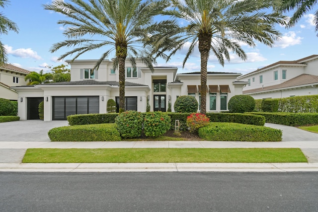 view of front facade with a garage, concrete driveway, and stucco siding