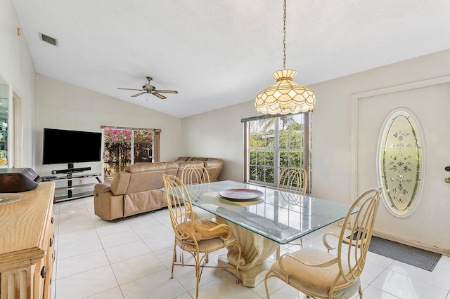 dining room featuring light tile patterned floors, visible vents, vaulted ceiling, a textured ceiling, and ceiling fan