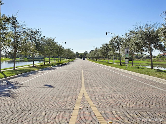 11603 SW Lake Park Dr, Port Saint Lucie, FL 34987 - view of street with street lights, curbs, and a water view