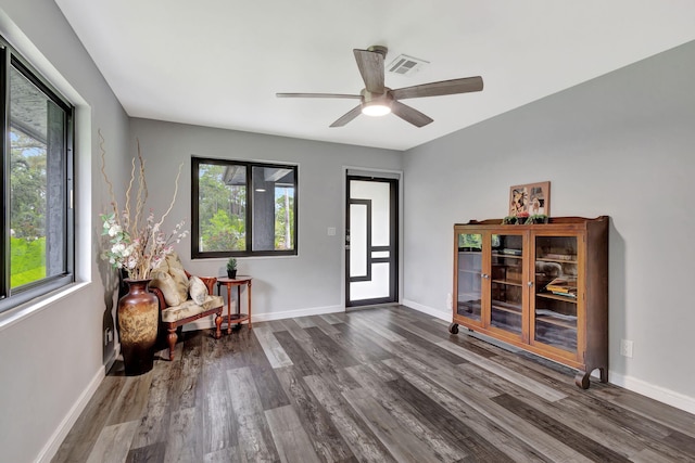 living area featuring dark wood-style floors, visible vents, and baseboards