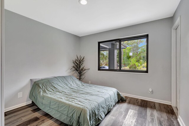 bedroom with baseboards and wood finished floors