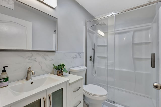 bathroom with toilet, a stall shower, tile walls, and vanity