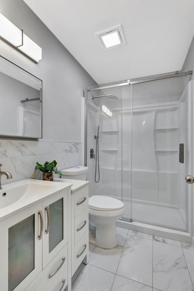 bathroom with marble finish floor, tile walls, toilet, a stall shower, and vanity