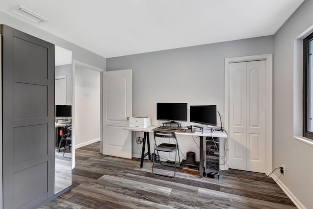 office space featuring wood finished floors, visible vents, and baseboards