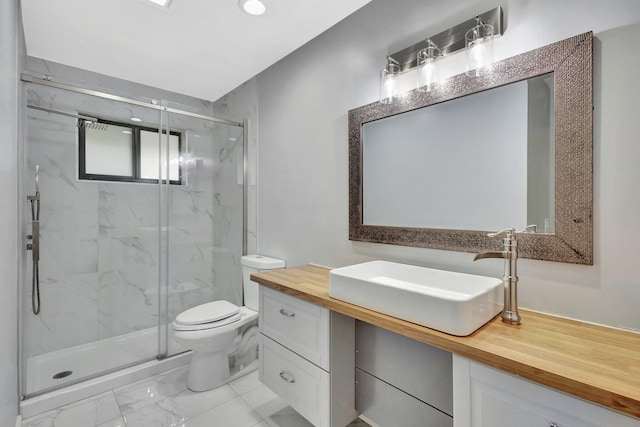 bathroom with toilet, marble finish floor, a marble finish shower, and vanity