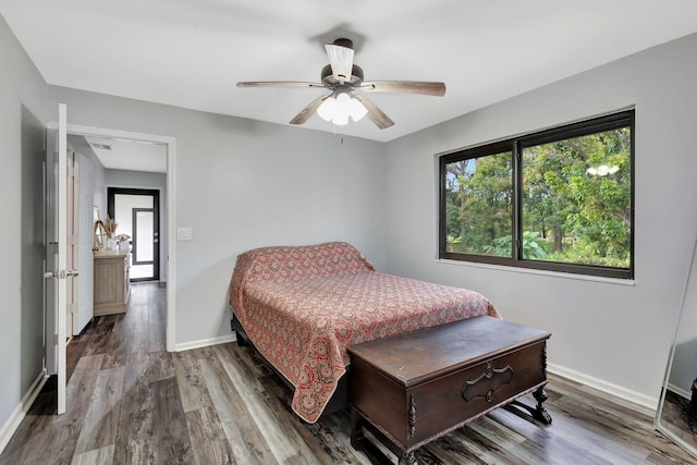 bedroom featuring ceiling fan, wood finished floors, and baseboards