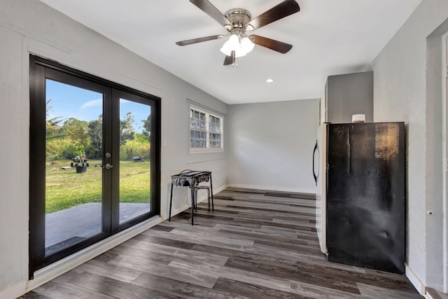 interior space featuring ceiling fan, baseboards, dark wood-style flooring, and french doors