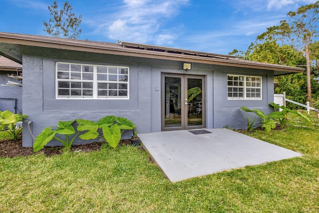 entrance to property with a lawn and stucco siding