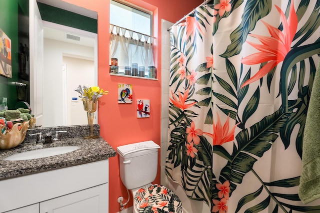 bathroom featuring toilet, vanity, and visible vents