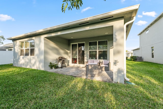 back of property with central AC, a lawn, a patio area, and stucco siding