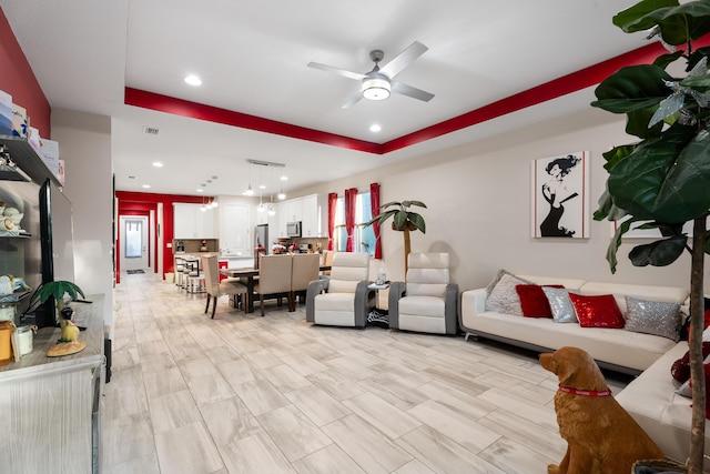 living area featuring visible vents, a raised ceiling, a ceiling fan, and recessed lighting