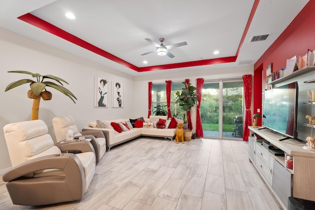 living room with recessed lighting, a raised ceiling, and visible vents