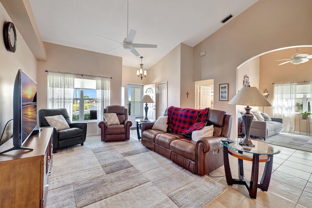 living room with ceiling fan with notable chandelier, high vaulted ceiling, visible vents, and a healthy amount of sunlight