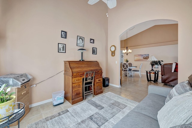 living area featuring arched walkways, light tile patterned flooring, baseboards, and ceiling fan with notable chandelier