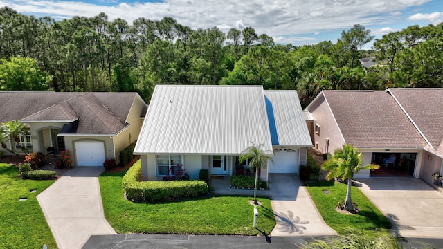 view of front of property with stucco siding, concrete driveway, covered porch, an attached garage, and a front lawn