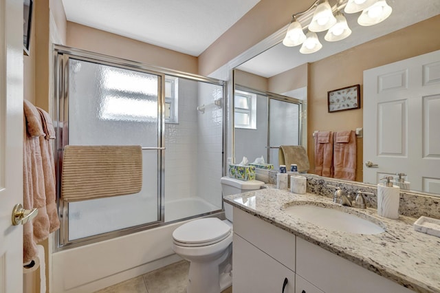 full bath featuring toilet, tile patterned flooring, enclosed tub / shower combo, and vanity