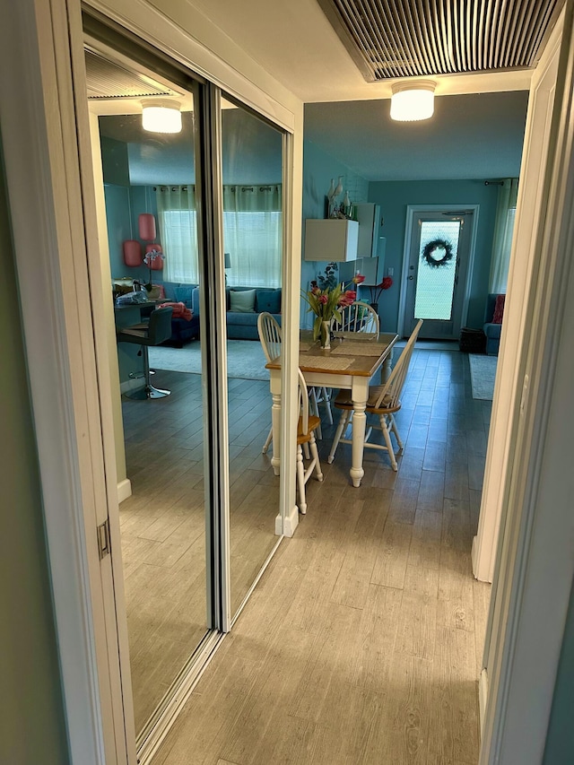 corridor with visible vents and hardwood / wood-style floors