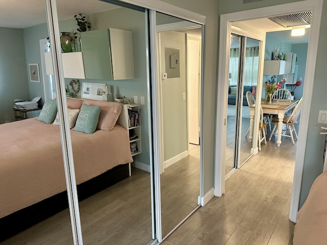 bedroom with a closet, light wood-type flooring, visible vents, and baseboards