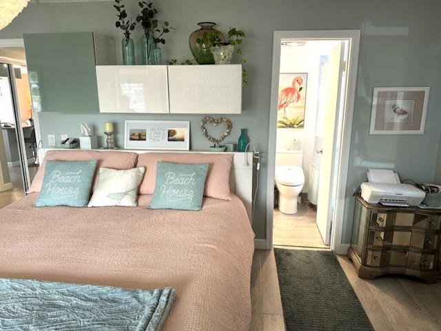 bedroom with ensuite bathroom and wood finished floors