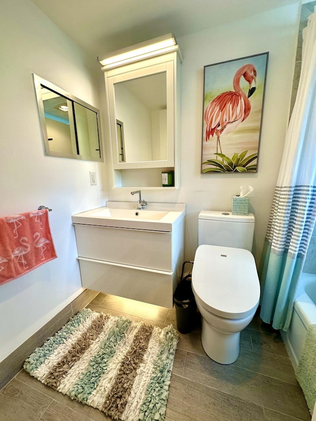 full bathroom featuring toilet, baseboards, vanity, and wood tiled floor