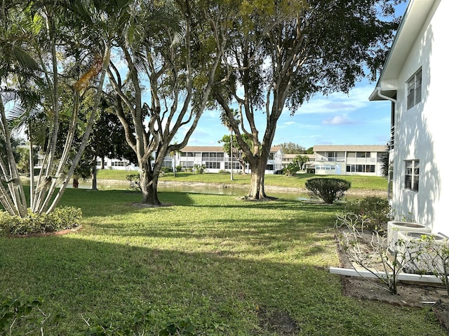 view of yard with a water view and central air condition unit