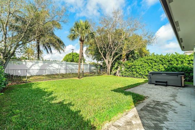 view of yard featuring a patio area, a hot tub, and a fenced backyard