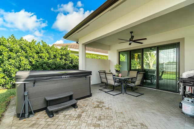 view of patio with a hot tub, ceiling fan, and outdoor dining space