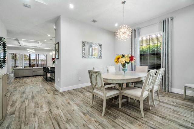 dining room featuring a chandelier, light wood finished floors, a wealth of natural light, and visible vents