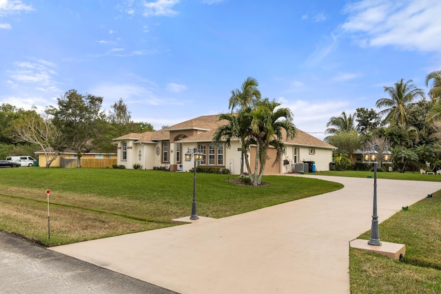 ranch-style house featuring a front lawn, concrete driveway, and stucco siding