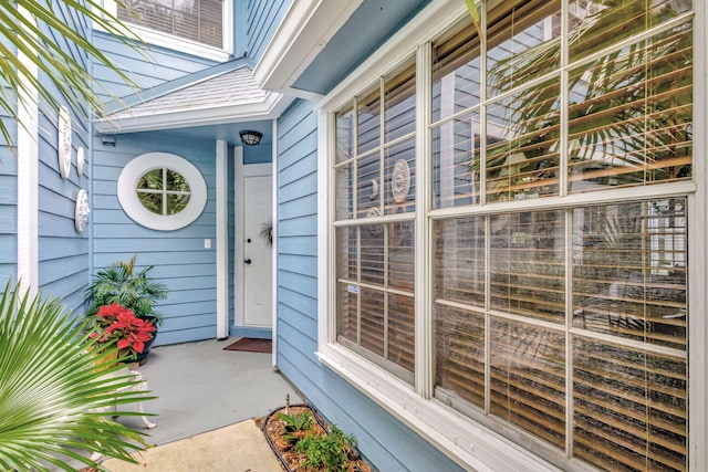 property entrance featuring a shingled roof