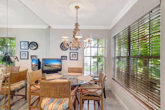 tiled dining room with a notable chandelier, baseboards, and crown molding