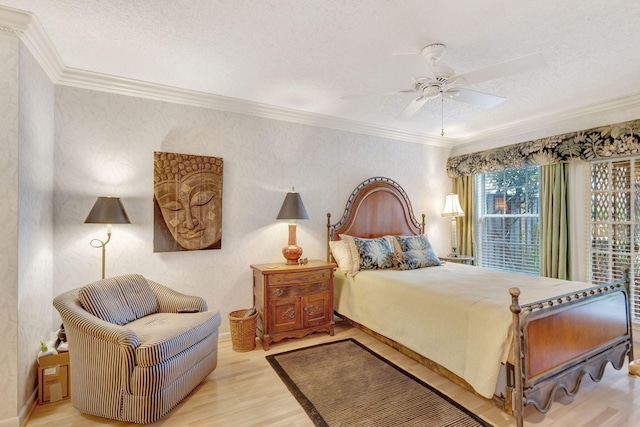 bedroom with a textured ceiling, ceiling fan, ornamental molding, and light wood-style floors