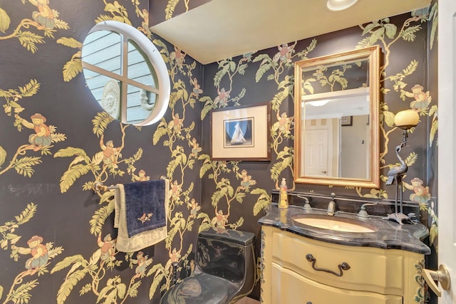 bathroom featuring vanity and wallpapered walls