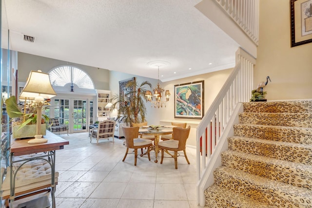 dining area featuring french doors, a notable chandelier, visible vents, a textured ceiling, and stairs