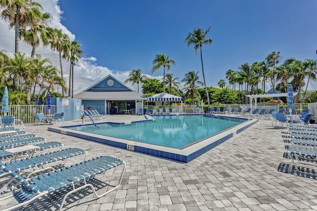 community pool with fence and a patio