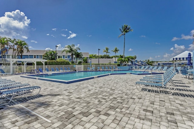 community pool with fence and a patio