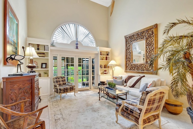 sitting room featuring french doors, plenty of natural light, a high ceiling, and light tile patterned floors