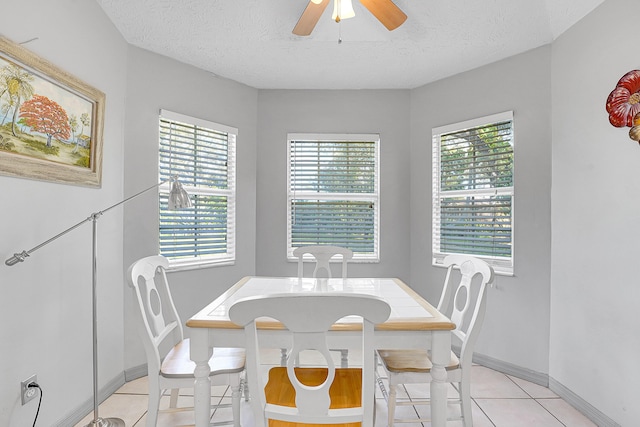 dining area featuring ceiling fan, baseboards, a textured ceiling, and light tile patterned flooring