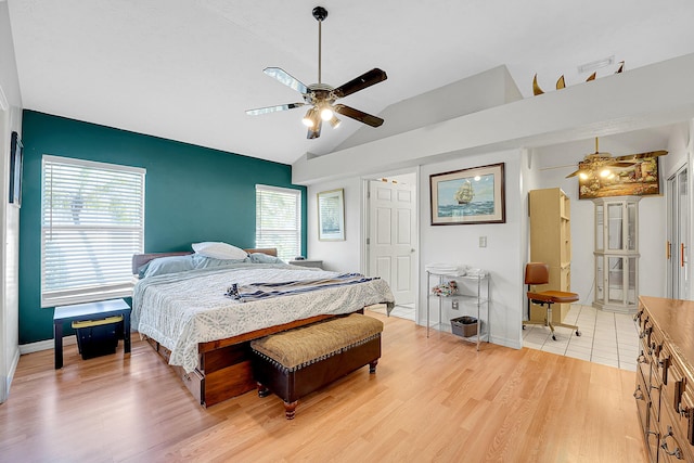 bedroom featuring a ceiling fan, vaulted ceiling, baseboards, and wood finished floors