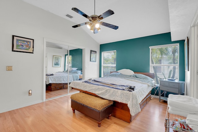 bedroom featuring lofted ceiling, visible vents, a ceiling fan, a closet, and light wood-type flooring